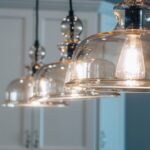 Elegante glazen hanglamp boven een stijlvolle eettafel in een moderne woonkamer.