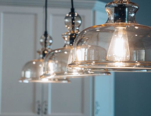 Elegante glazen hanglamp boven een stijlvolle eettafel in een moderne woonkamer.