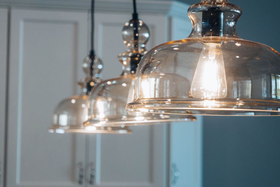 Elegante glazen hanglamp boven een stijlvolle eettafel in een moderne woonkamer.