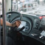 Een buschauffeur die passagiers veilig vervoert in Zwolle, met een mooie achtergrond van de stad en bussen.