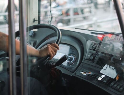 Een buschauffeur die passagiers veilig vervoert in Zwolle, met een mooie achtergrond van de stad en bussen.